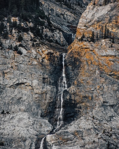 瀑布之间崎岖的山在白天
